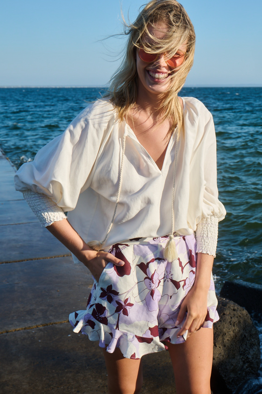 model posing near water wearing white blouse