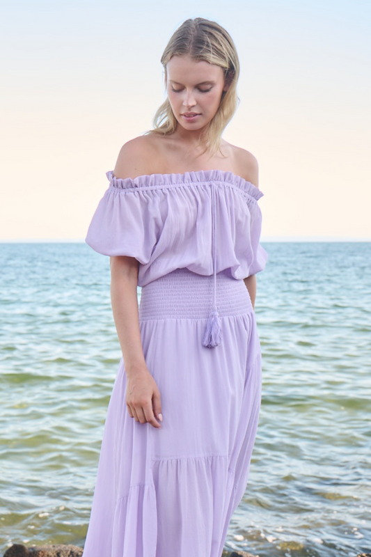model wearing lilac maxi dress near water
