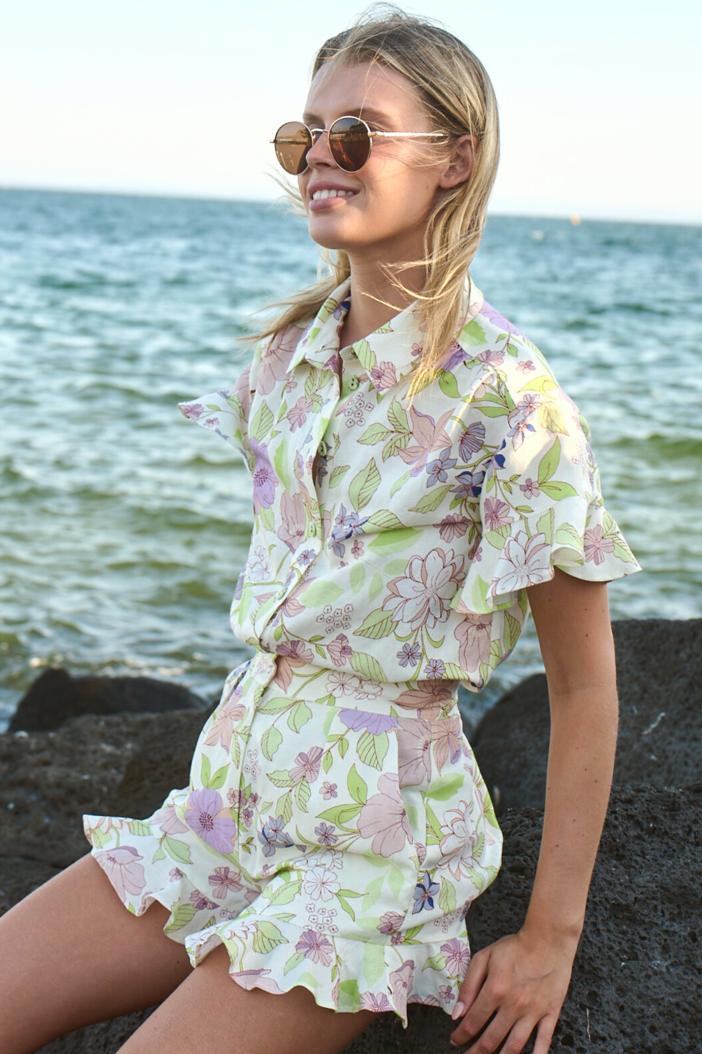 model sitting on rocks wearing matching set