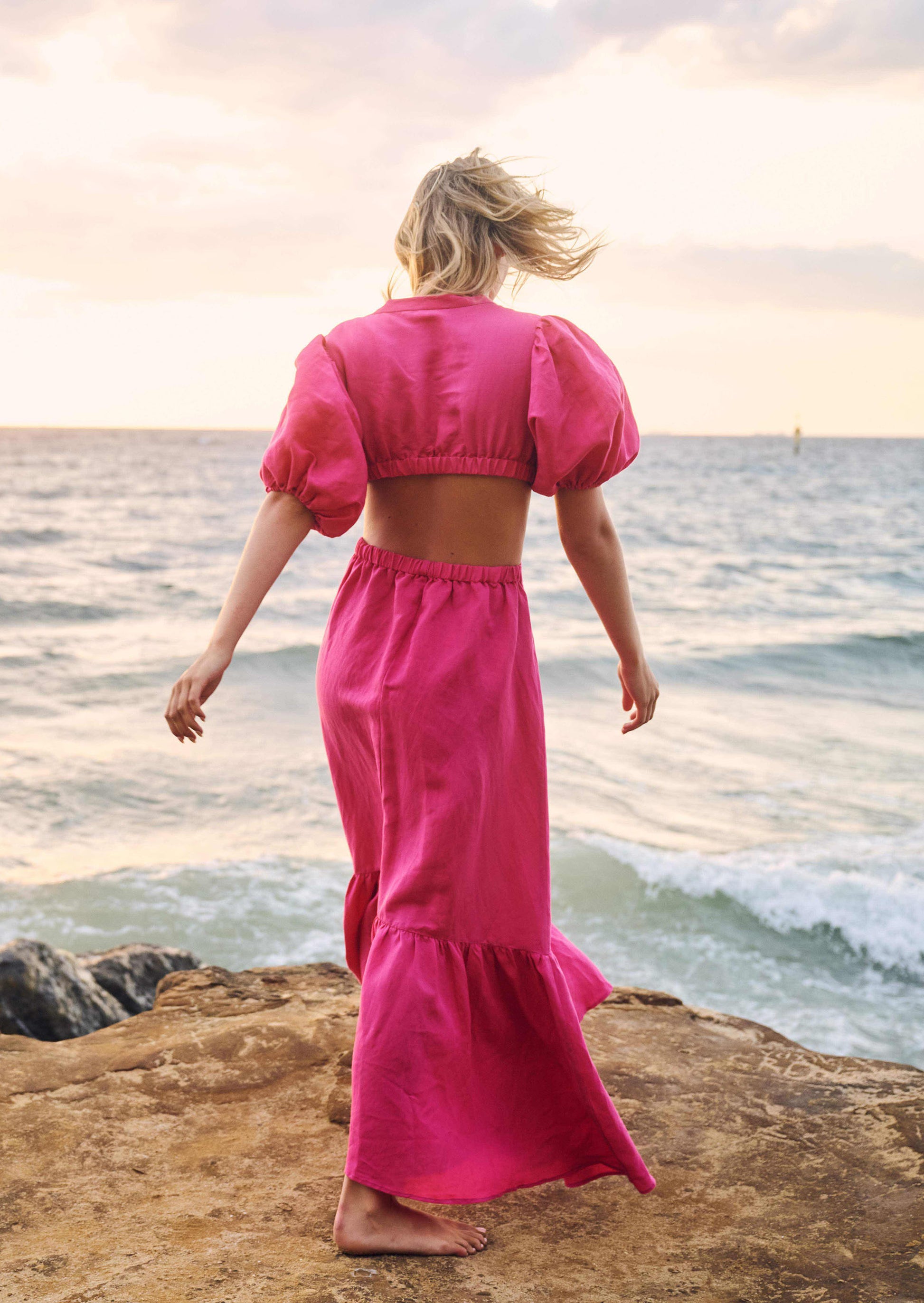 model wearing pink maxi dress at beach
