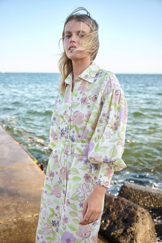 model posing near rocks on pier wearing linen shirt dress