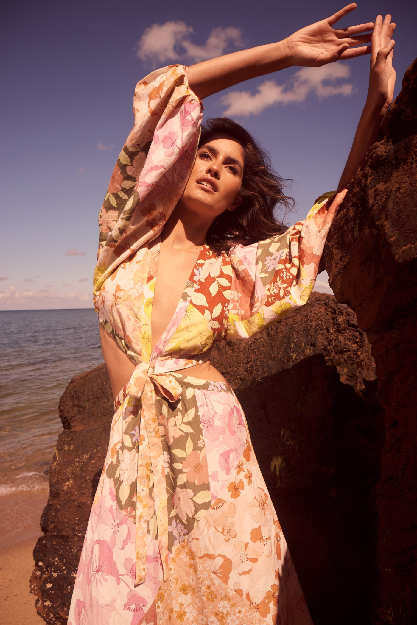 model wearing long sleeve printed dress at the beach