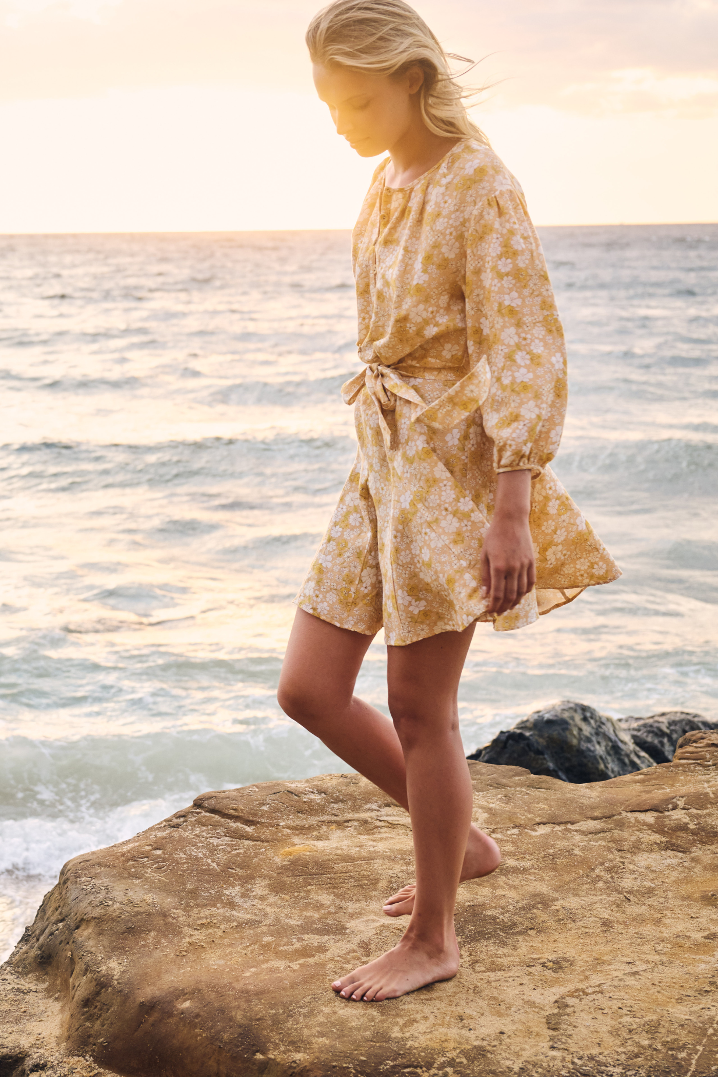 Model at beach wearing flowing mini dress