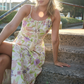 model sitting on steps wearing pastel printed linen dress