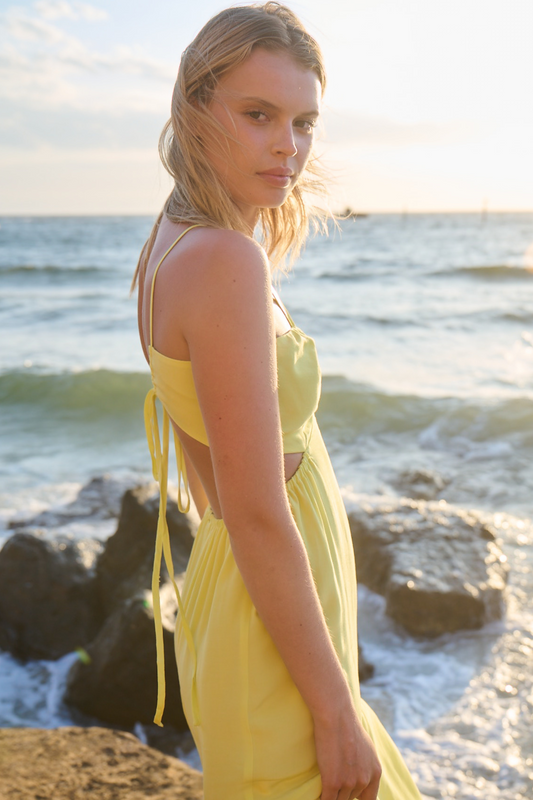 black rock photoshoot model wearing yellow wedding guest dress