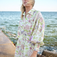 model posing near rocks on pier wearing linen shirt dress